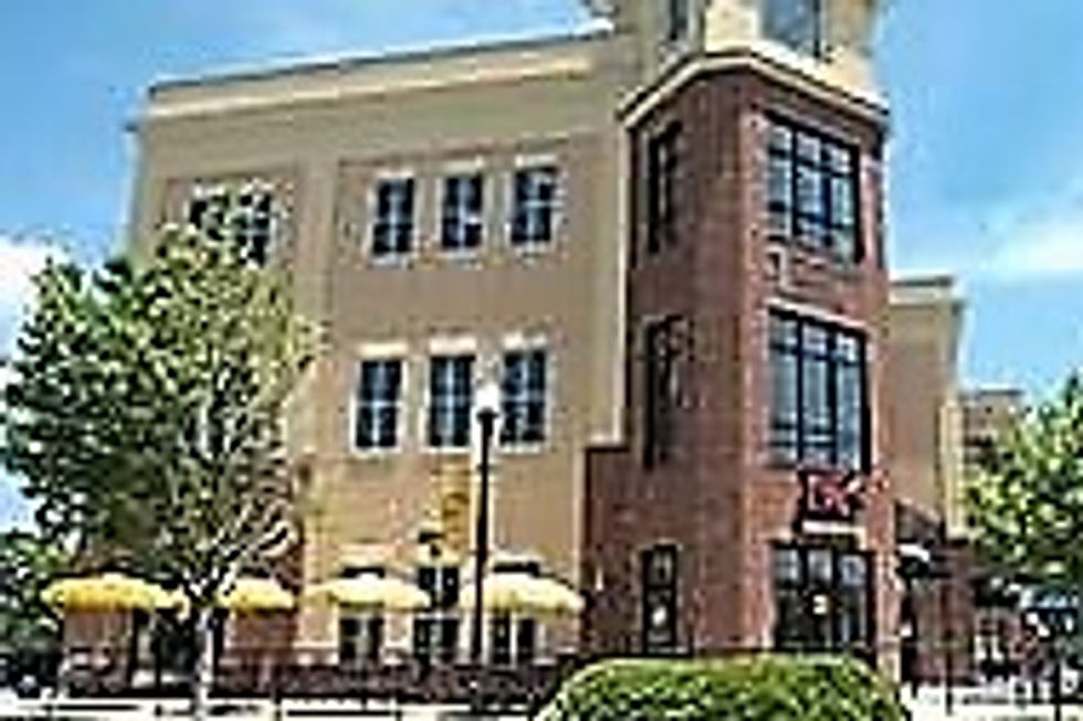 Modern building with brick tower, outdoor patio, yellow umbrellas