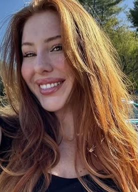 Smiling woman with long red hair outdoors