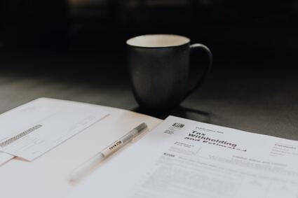 coffee mug pen and folder of tax forms