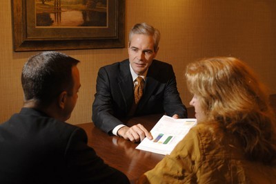 A consultant discussing financial charts with a couple.