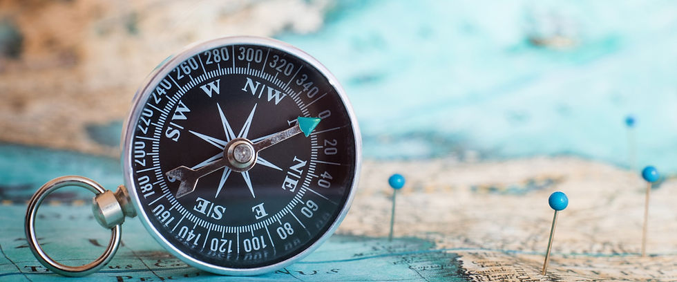 Compass and blue map pins on a world map