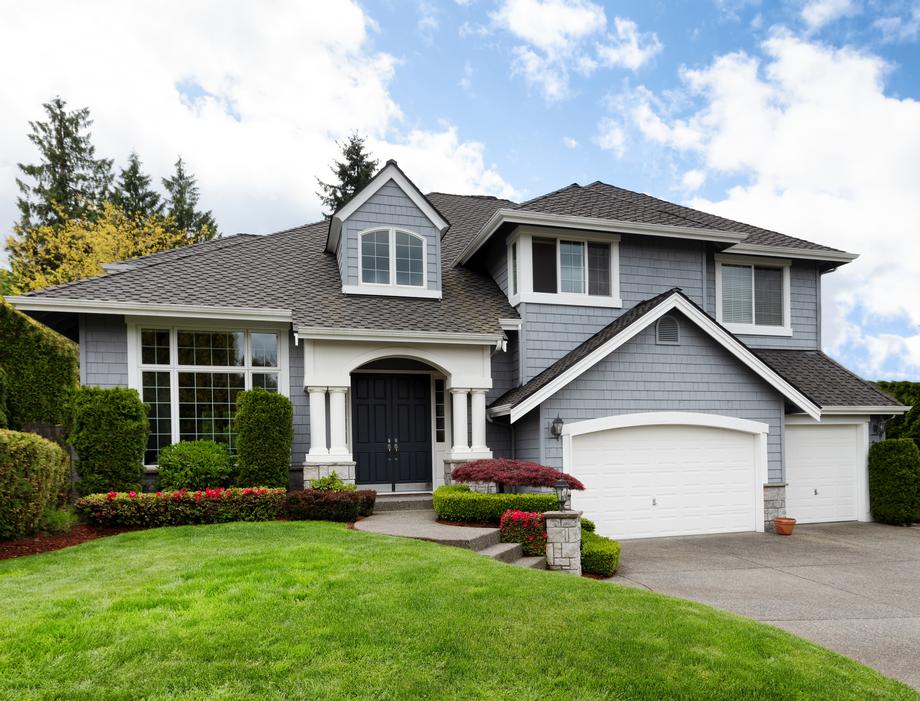 Modern two-story blue house with white trim and green lawn