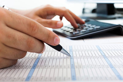 tax preparer hand with calculator and pen