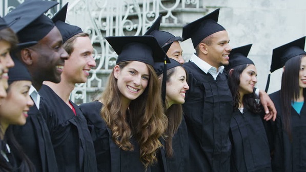 Diverse group of smiling graduates in caps and gowns