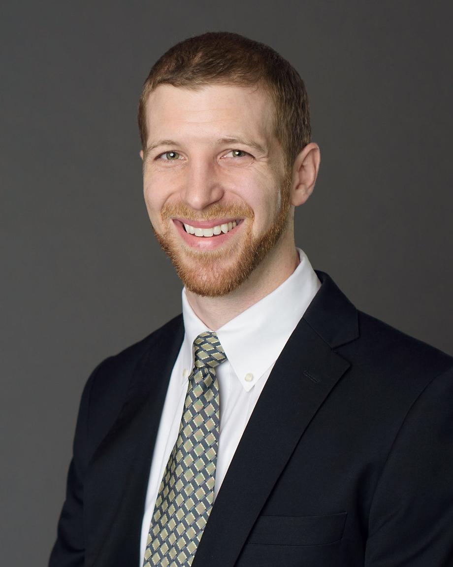 Smiling male advisor in a suit and patterned tie.