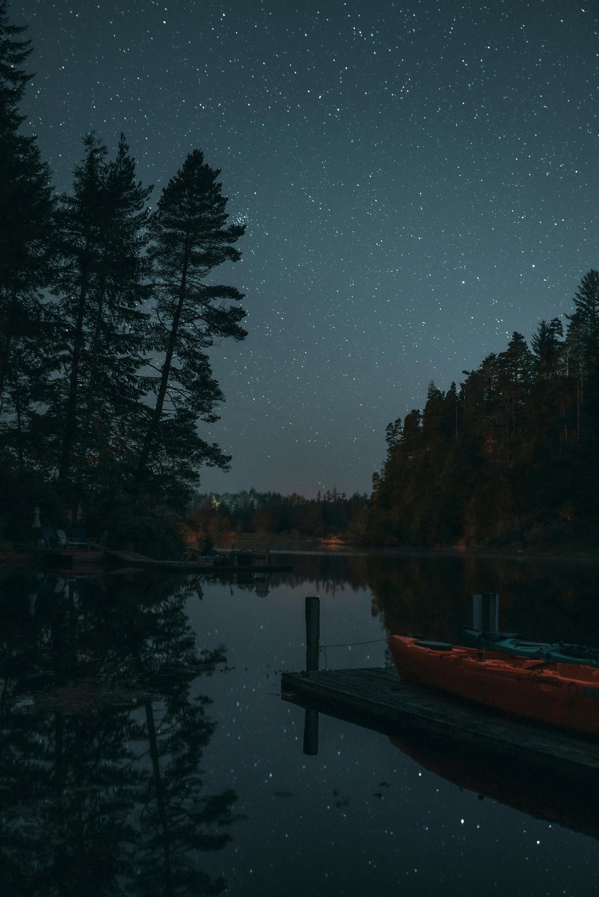 Kayak on a quiet lake under a star-filled sky