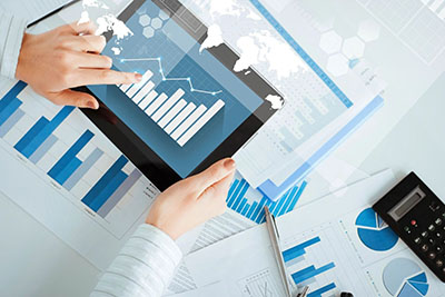 person's hand pointing at bar chart on tablet