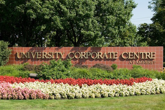 University Corporate Centre at Amherst sign with flowers