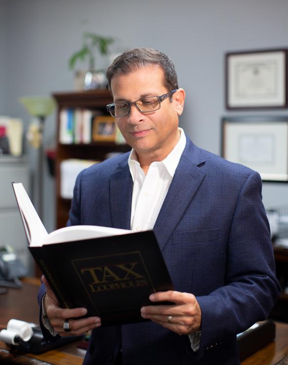 Professional reading a tax book for tax services.