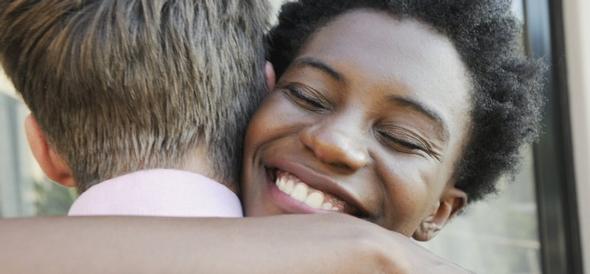 Smiling woman hugging a man for Article of the Month.