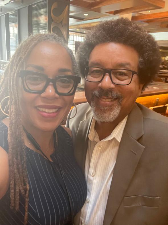 Smiling couple wearing glasses in a restaurant setting.