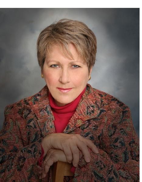 Woman with short brown hair in a patterned blazer