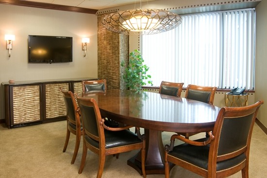 Modern conference room with oval table and wall-mounted TV