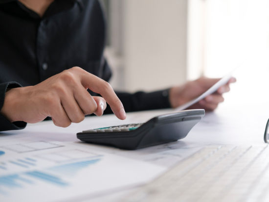 Person using calculator to manage financial assets
