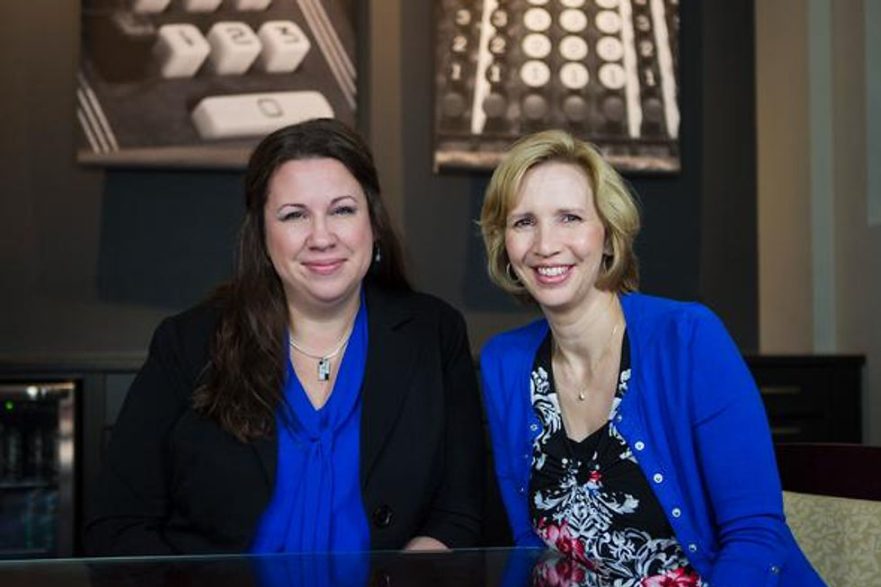 Two smiling women sitting together in a professional setting