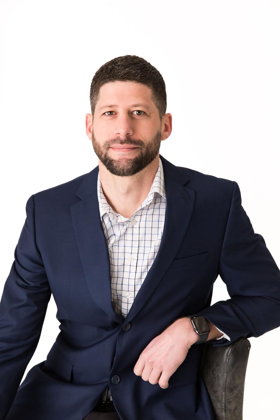 Professional man in a navy blazer and patterned shirt.