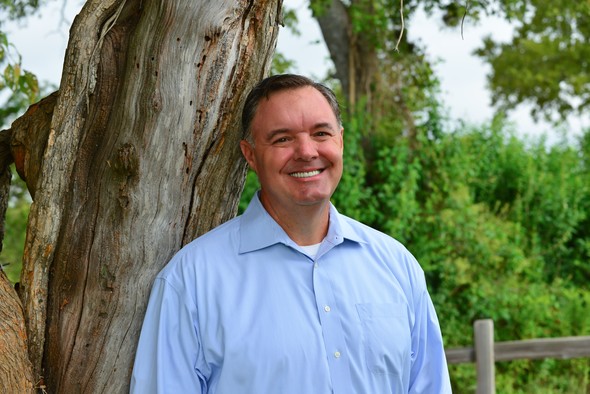 Professional smiling in a blue shirt at Our Firm