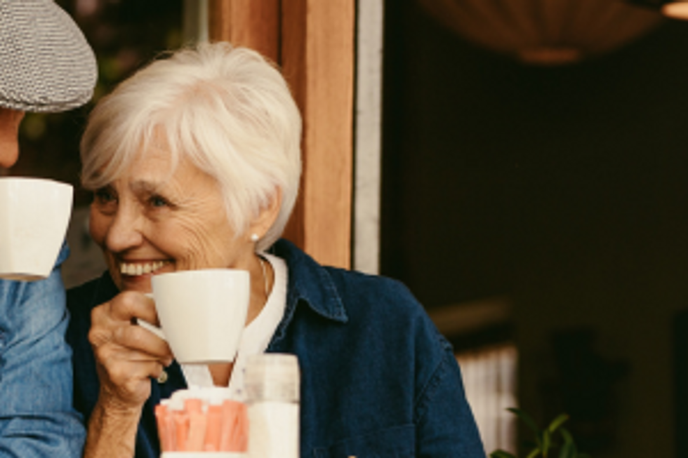 Smiling senior woman enjoying a cup of coffee outdoor.