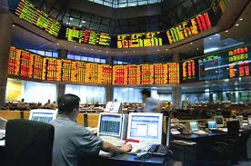 Stock exchange trading floor with digital ticker displays.