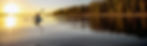 Person kayaking on a lake at sunset with sunset