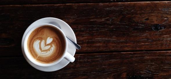 Top view of latte with heart art on a wooden table
