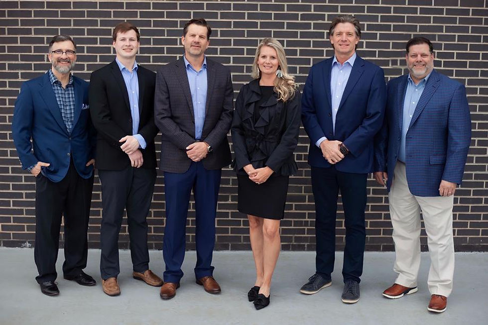 Six professionals standing against a brick wall