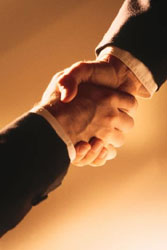 Two professionals shaking hands symbolizing partnership.