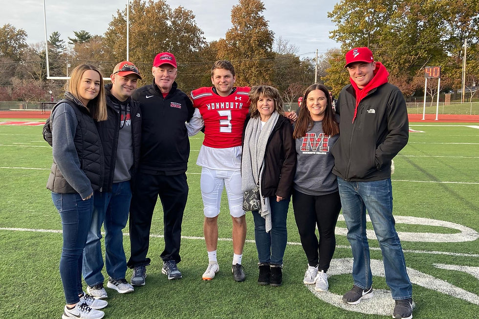 Football player with family on the field after a game.