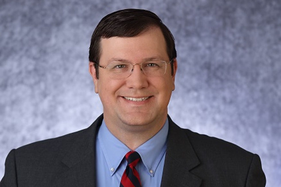 Smiling man with glasses in a suit and tie