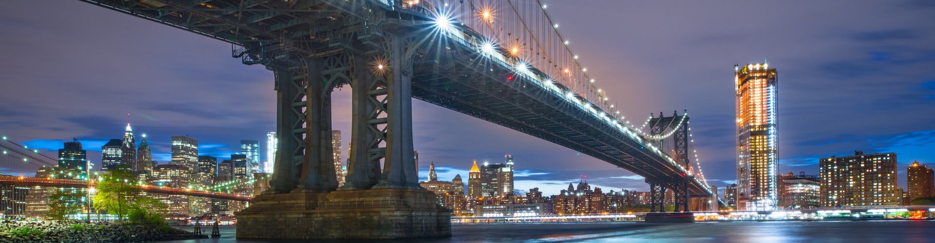 Manhattan Bridge and New York City skyline at dusk