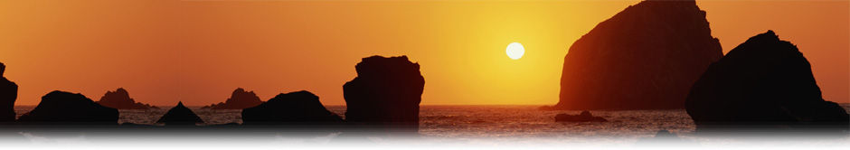 Sunset over silhouettes of large coastal rock formations