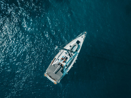 Aerial view of a sailboat on calm blue water