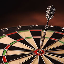 Dart hitting the bullseye on a dartboard.