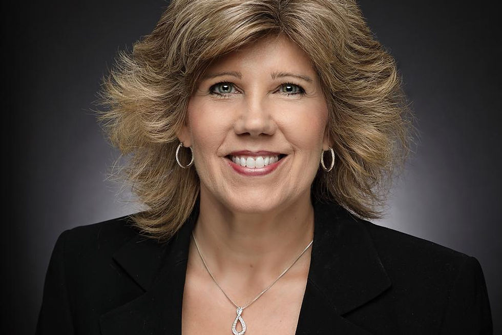 Smiling woman with blonde hair in a professional black blazer