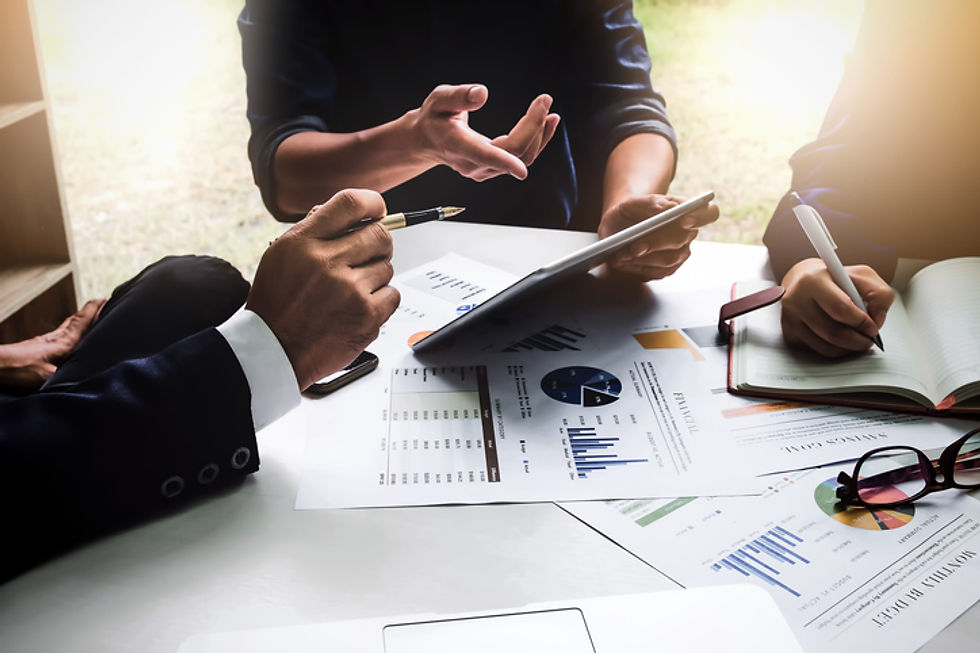 Business professionals reviewing data charts and a tablet during a meeting