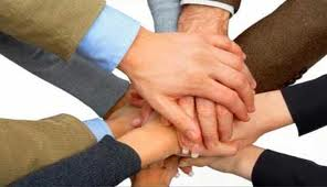 A group of hands stacked in a pile representing unity.