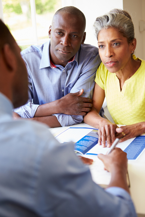 Senior couple discussing qualifications with a professional.