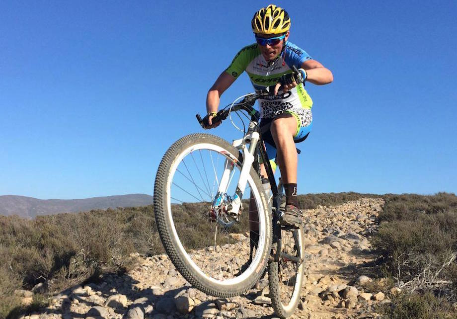 Cyclist riding a mountain bike on a rocky trail.