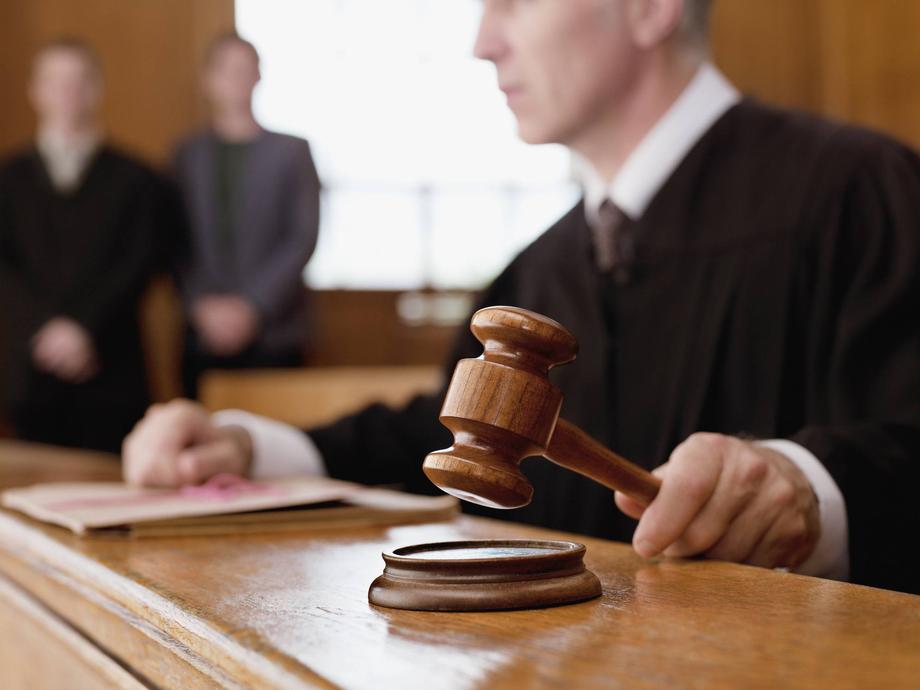 Judge holding a wooden gavel in a courtroom