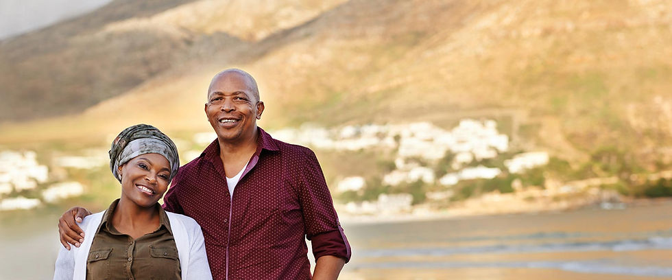 Smiling couple standing together outdoors on a beach