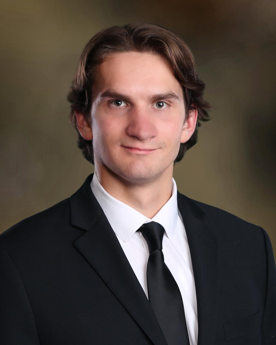 Portrait of a male team member in a black suit and tie.