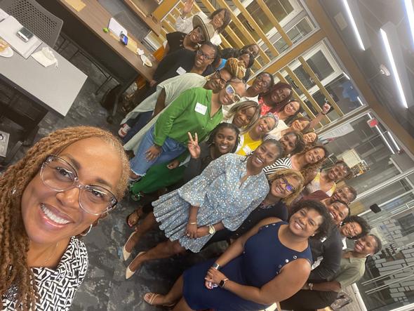 Large group of smiling women posing for a selfie indoors.