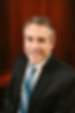 Andy Price smiling in a suit