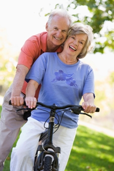 Smiling senior couple on a bicycle outdoors