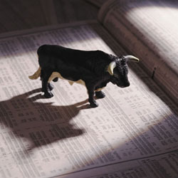 Small black bull figurine on a financial newspaper.