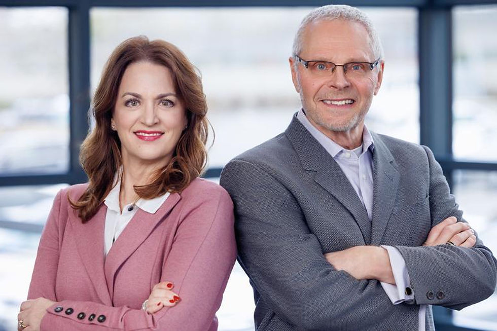 Professional man and woman smiling with arms crossed