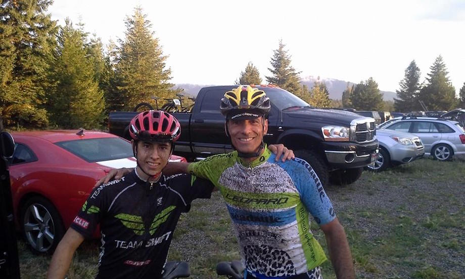 Two cyclists in a community event posing in a parking lot