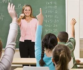 Teacher pointing to students with raised hands in class