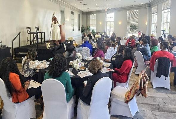 Woman speaking at a podium to an audience at a seminar.