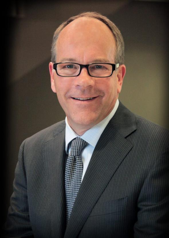 Portrait of a smiling male associate in a suit and glasses